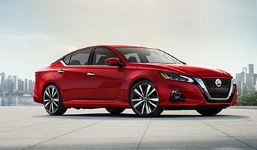 2023 Nissan Altima in red with city in background illustrating last year's 2022 model in Courtesy Nissan PA in Altoona PA